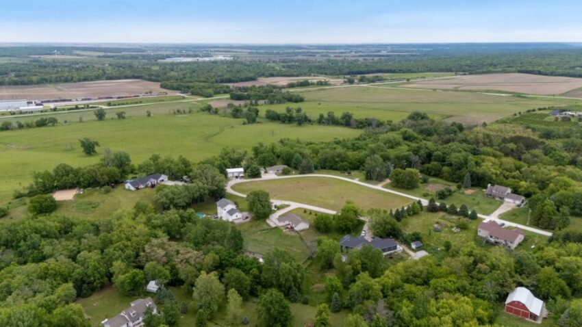 Aerial view of a fenced backyard with a garden and trees.