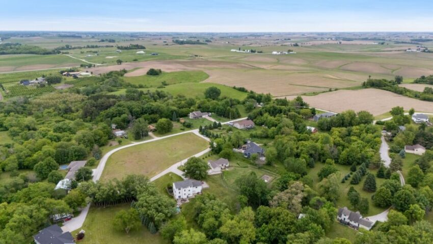 Aerial view of rural landscape with houses, trees, and fields.