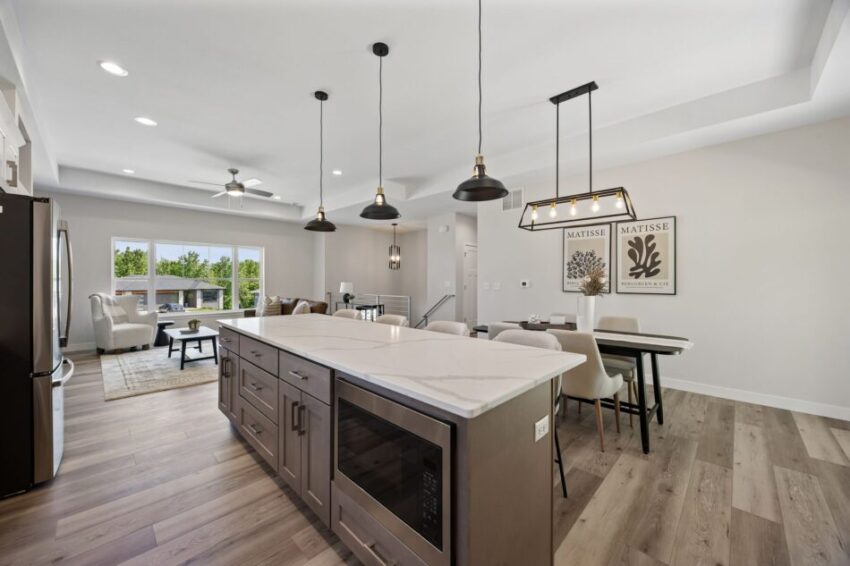 Modern kitchen with stainless steel stove, white cabinets, and quartz island.