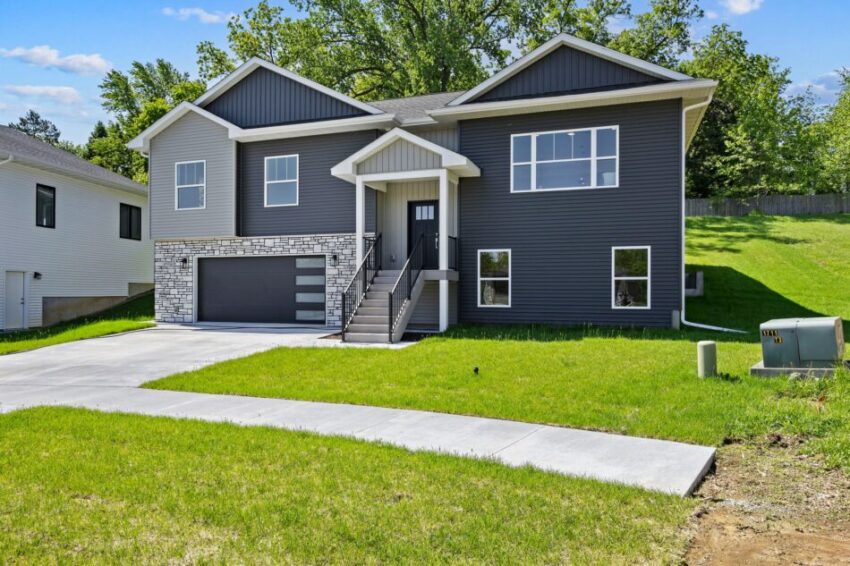 Modern two-story house with gray siding and a spacious front lawn.