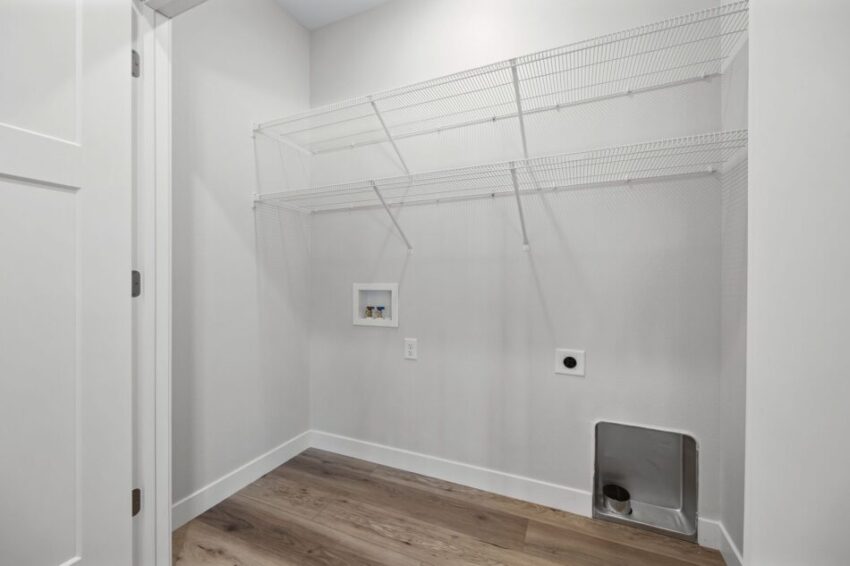 Empty laundry room with wire shelving and light gray walls.