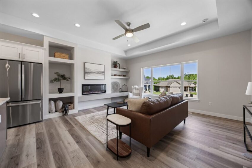 Modern living room with luxury flooring, ceiling fan, and large windows.