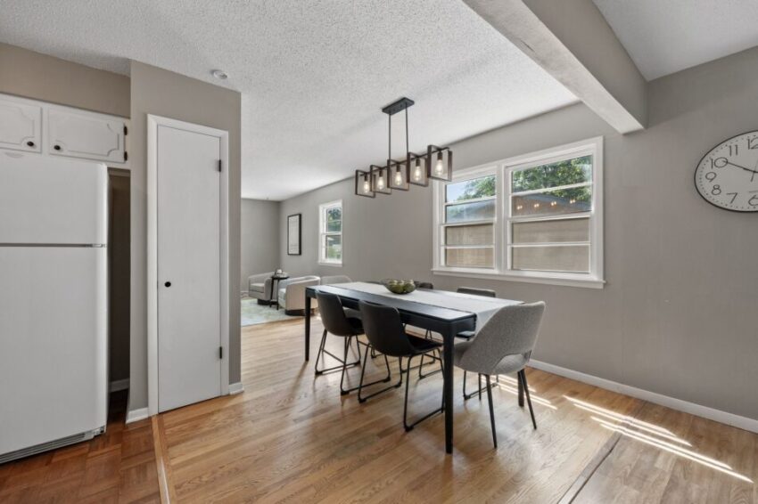Dining room with table, chairs, and large window.