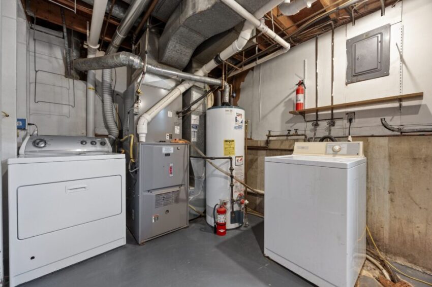 Basement laundry room with washer, dryer, and water heater.